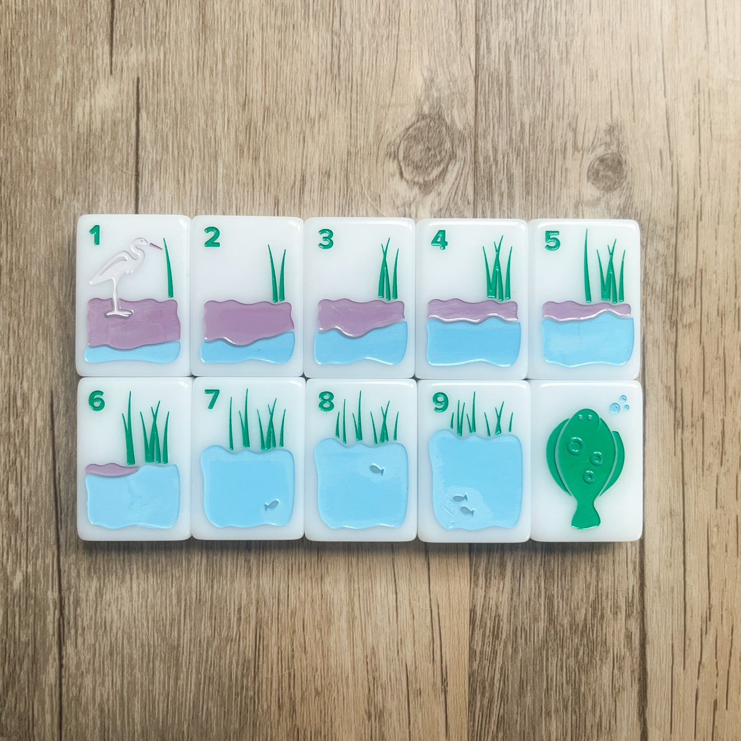 The Bam suit tiles 1-9 and the Flounder Green Dragon featuring images of the marsh and tides
